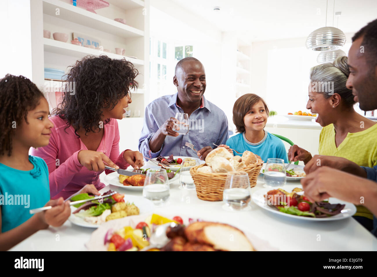 Multi generazione famiglia americana africana mangiare pasto a casa Foto Stock