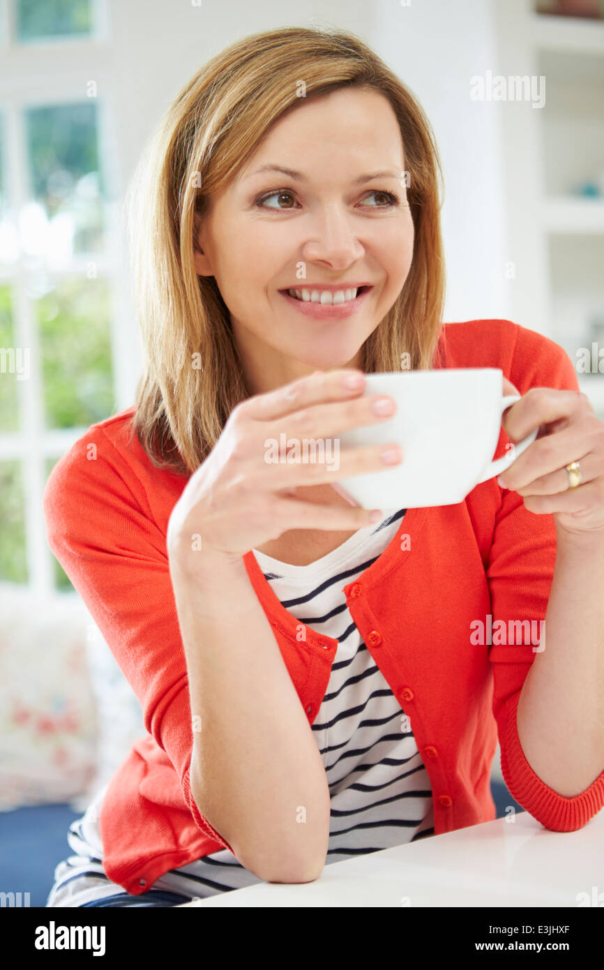 La donna in un momento di relax a casa con bevanda calda Foto Stock