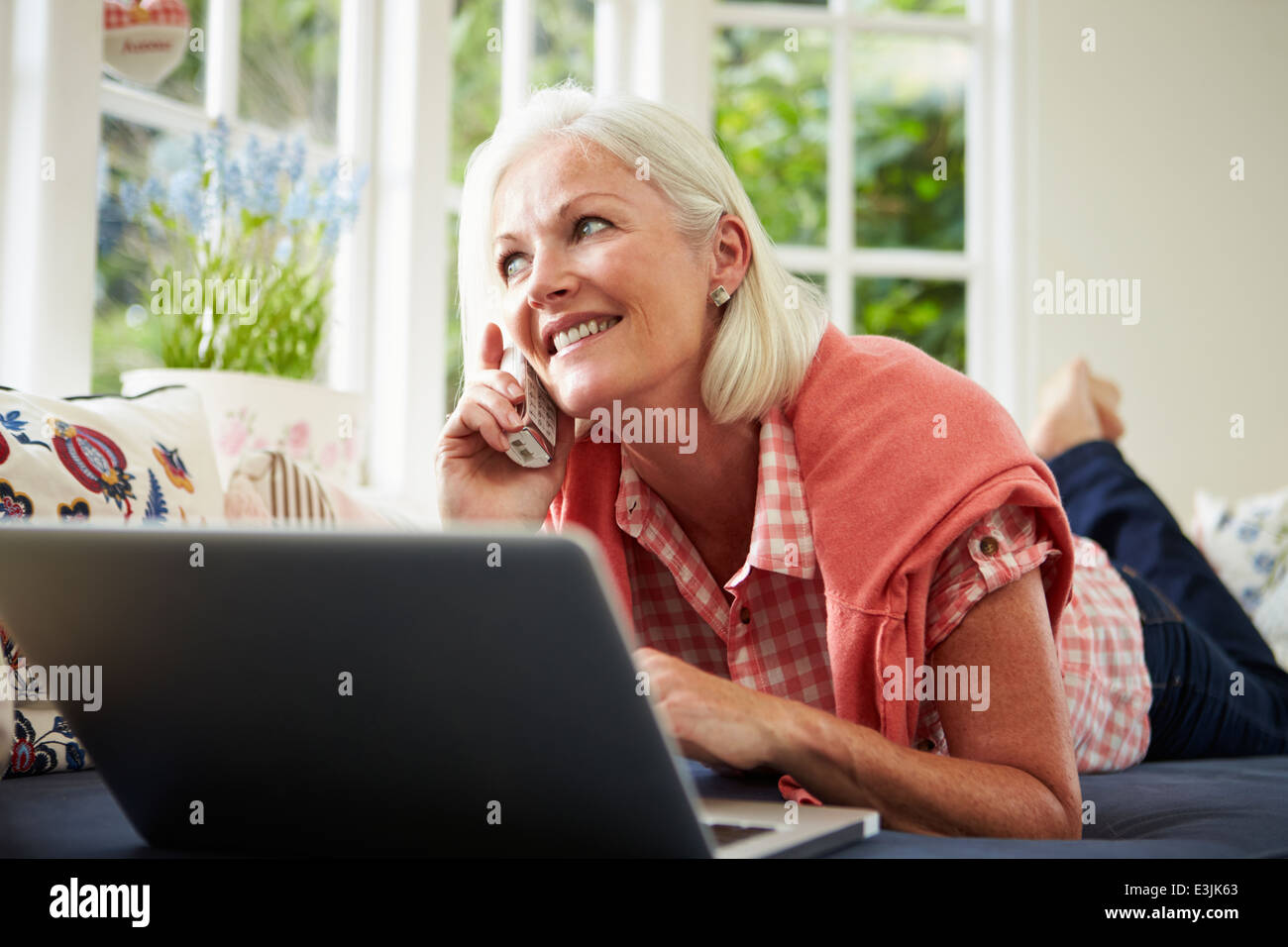 Donna di mezza età ordinazione di voce sul telefono Foto Stock