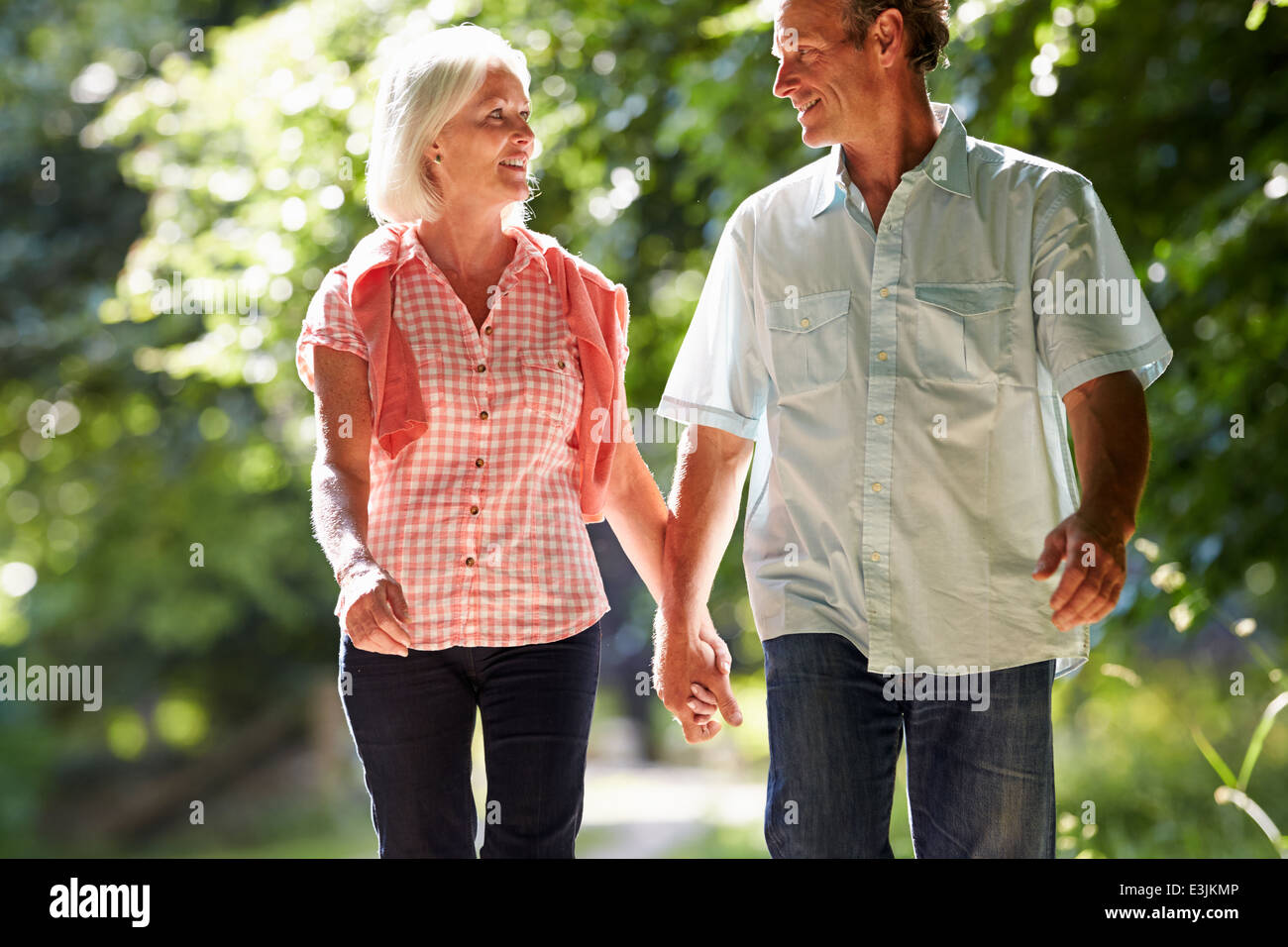 Romantica Coppia di mezza età camminando lungo il sentiero di campagna Foto Stock