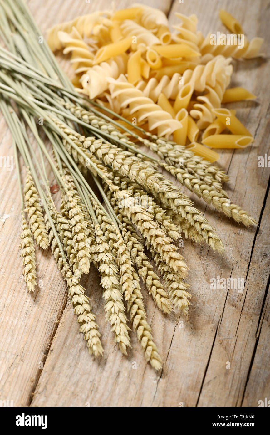 Spighe di grano mazzetto sul tavolo di legno con varietà di pasta Foto Stock