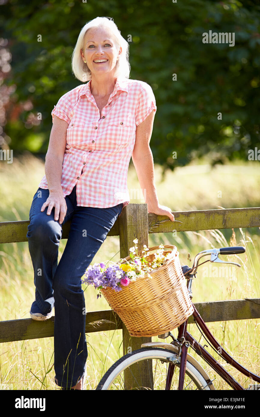Donna di mezza età rilassante sul Paese in bicicletta Foto Stock