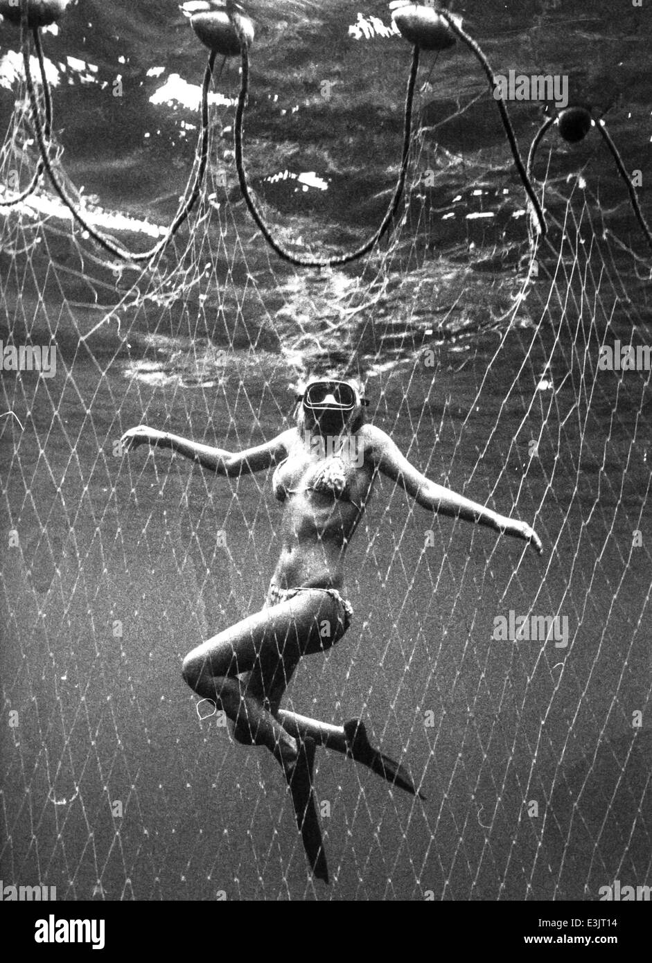 Donna sott'acqua in una rete da pesca,70's Foto Stock