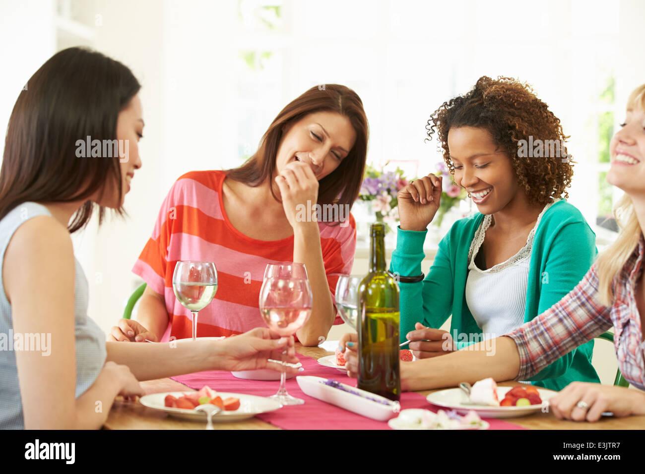 Il gruppo di donne seduti a tavola a mangiare il Dessert Foto Stock