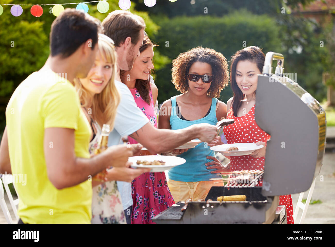 Gruppo di amici di barbecue all'aperto a casa Foto Stock