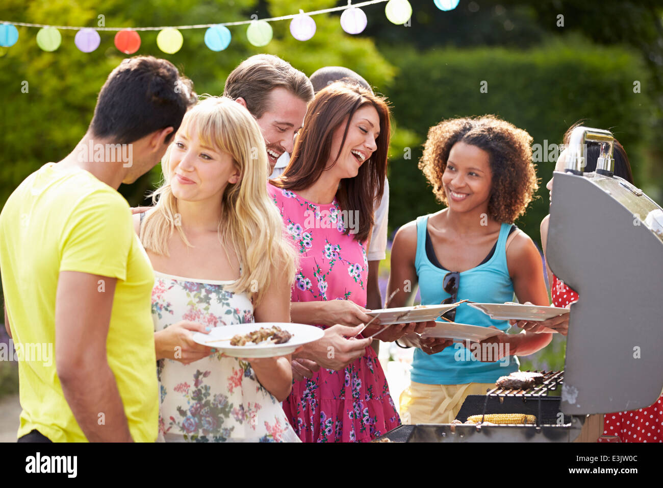 Gruppo di amici di barbecue all'aperto a casa Foto Stock