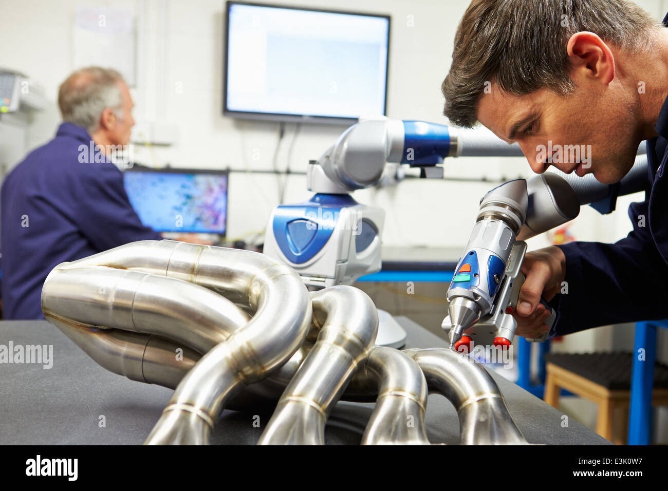 Due ingegneri utilizzando CMM computerizzata del braccio in fabbrica Foto Stock