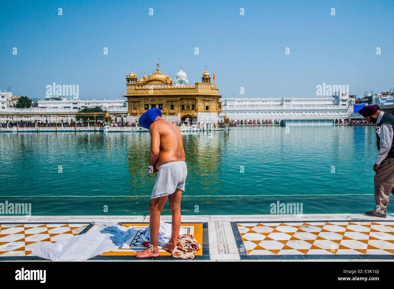 Pellegrini Sikh asciugando fuori dopo il bagno nella vasca di sacro che circonda il tempio d'oro di Amritsar, India Foto Stock