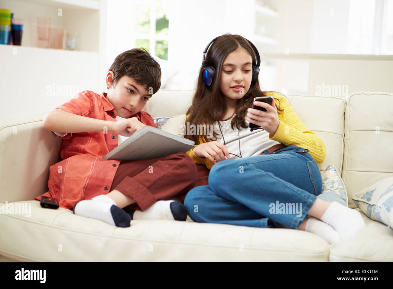 Bambini che giocano con tavoletta digitale e lettore MP3 Foto Stock