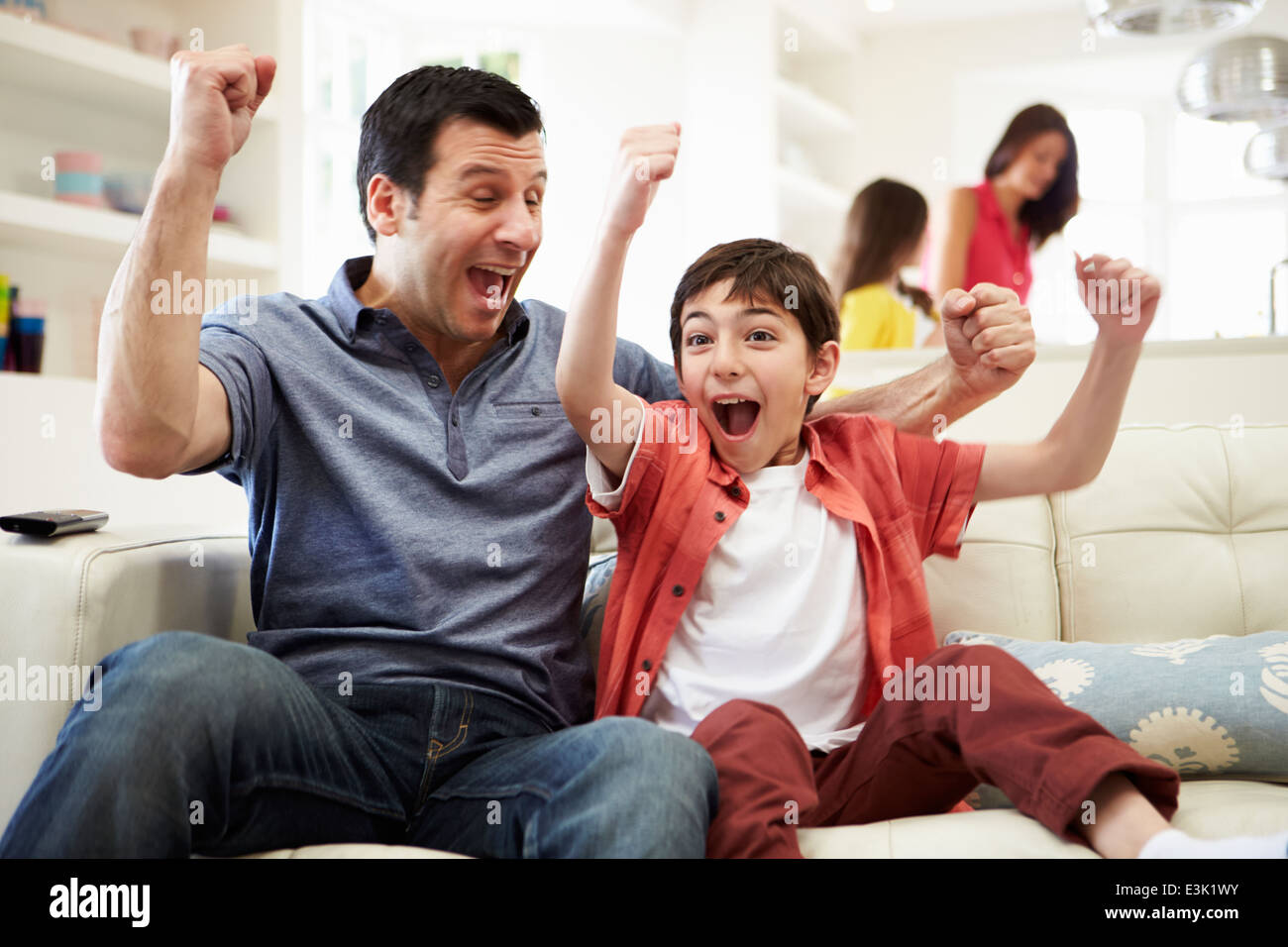 Padre e Figlio a guardare lo sport in TV Foto Stock
