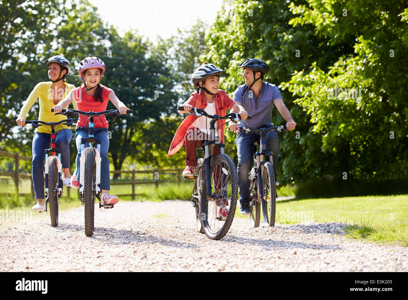 Famiglia di origine ispanica sul tragitto in bicicletta in campagna Foto Stock