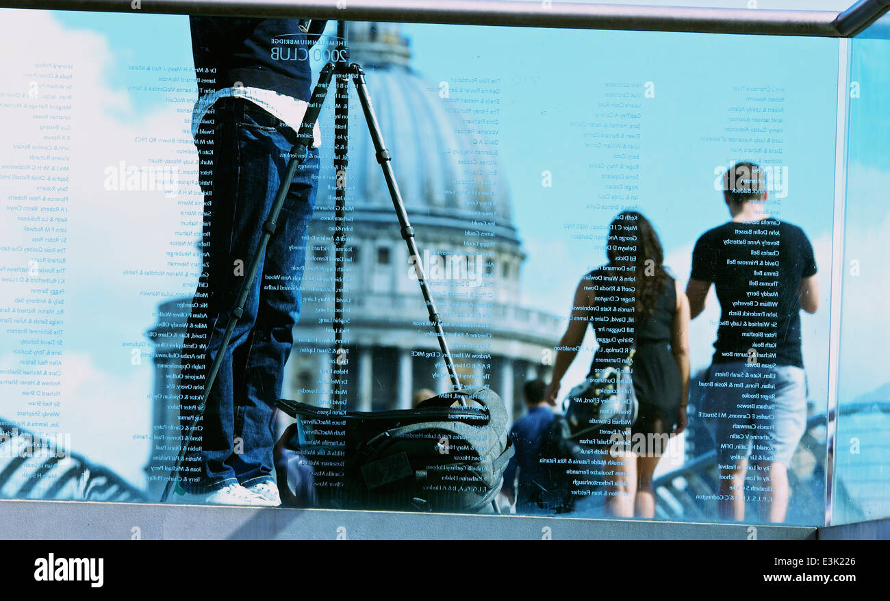 Vista attraverso il vetro inciso del Millennium Bridge di fotografo con treppiede e la Cattedrale di St Paul Londra Inghilterra Europa Foto Stock