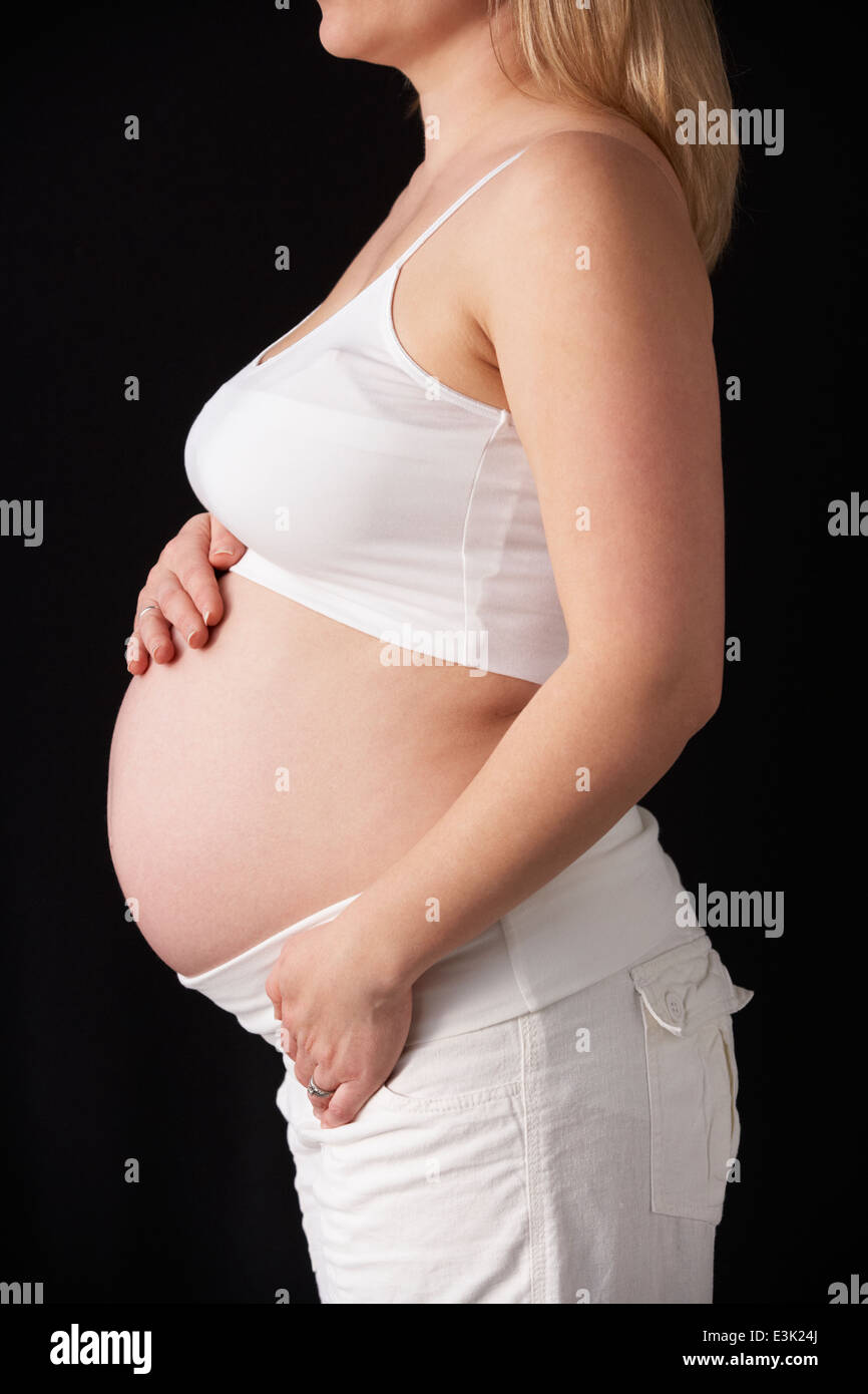 Close up ritratto di donna incinta su sfondo nero Foto Stock