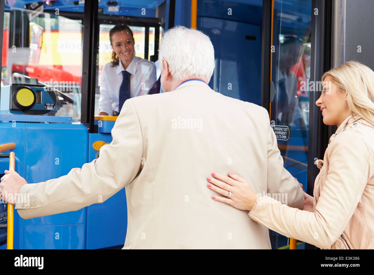 Donna Senior aiuta l uomo a bordo dei bus Foto Stock