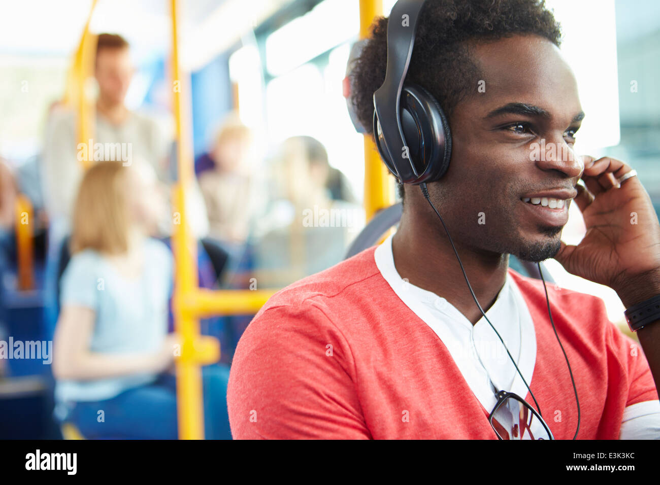 Uomo che indossa le cuffie per ascoltare musica in viaggio in autobus Foto Stock