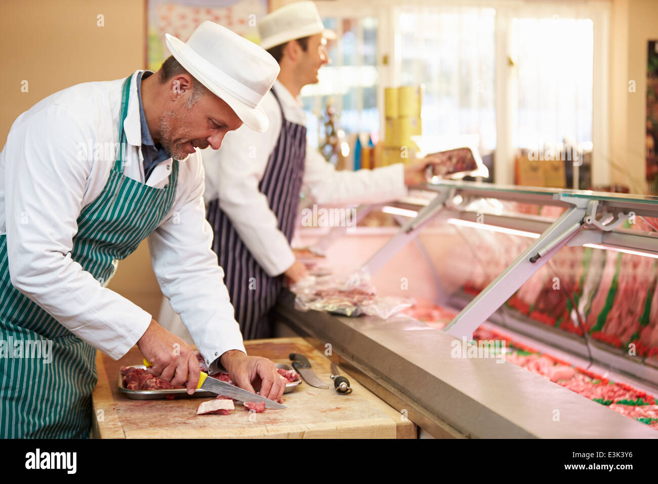 Due macellai di preparare la carne in negozio Foto Stock