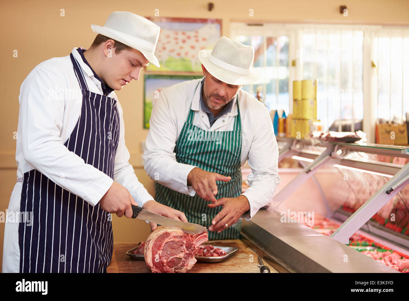 Macellaio apprendista di insegnamento come preparare carne Foto Stock