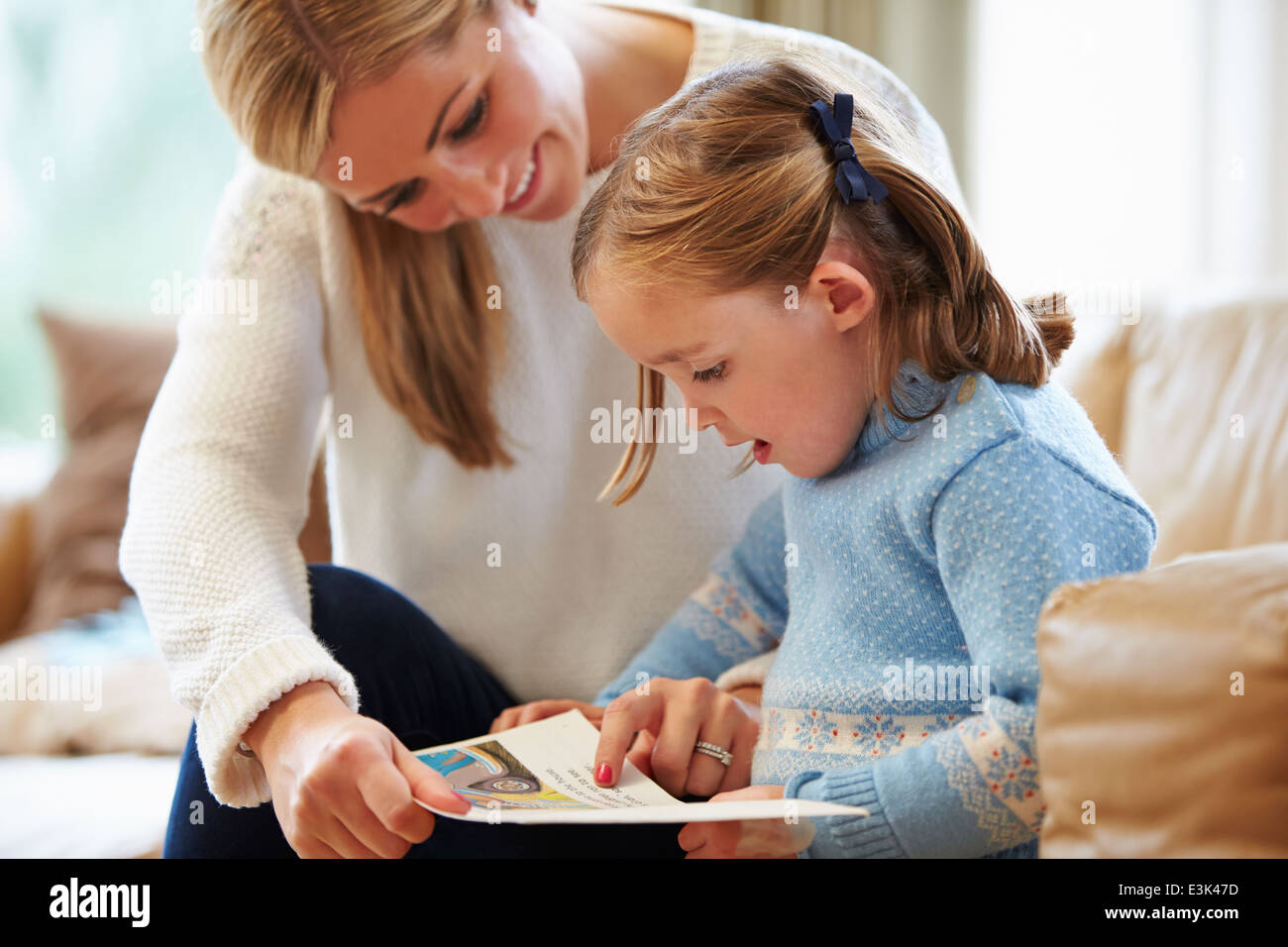 Madre e figlia alla lettura della storia a casa insieme Foto Stock