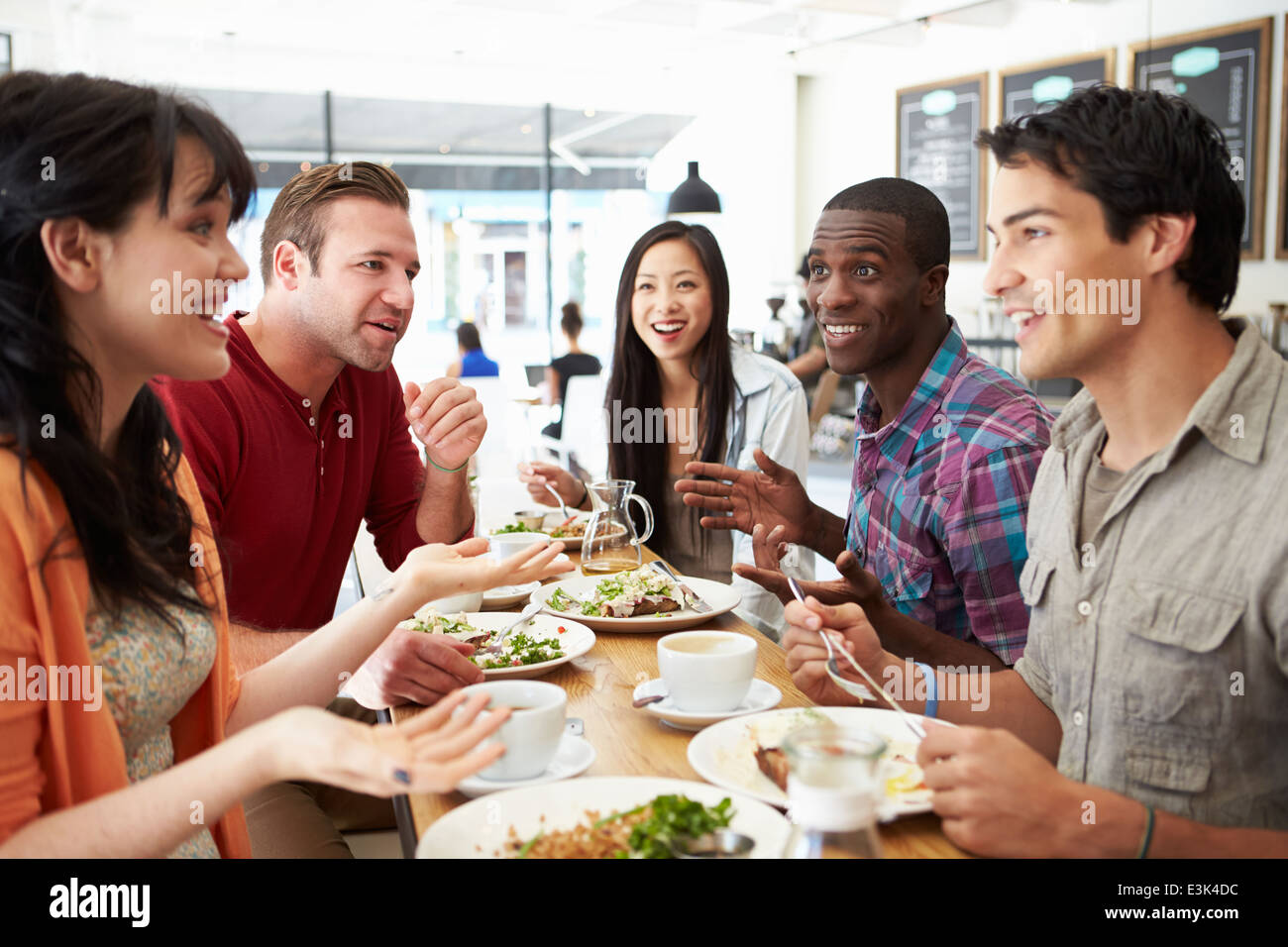 Gruppo di amici riuniti per il pranzo in un Coffee Shop Foto Stock
