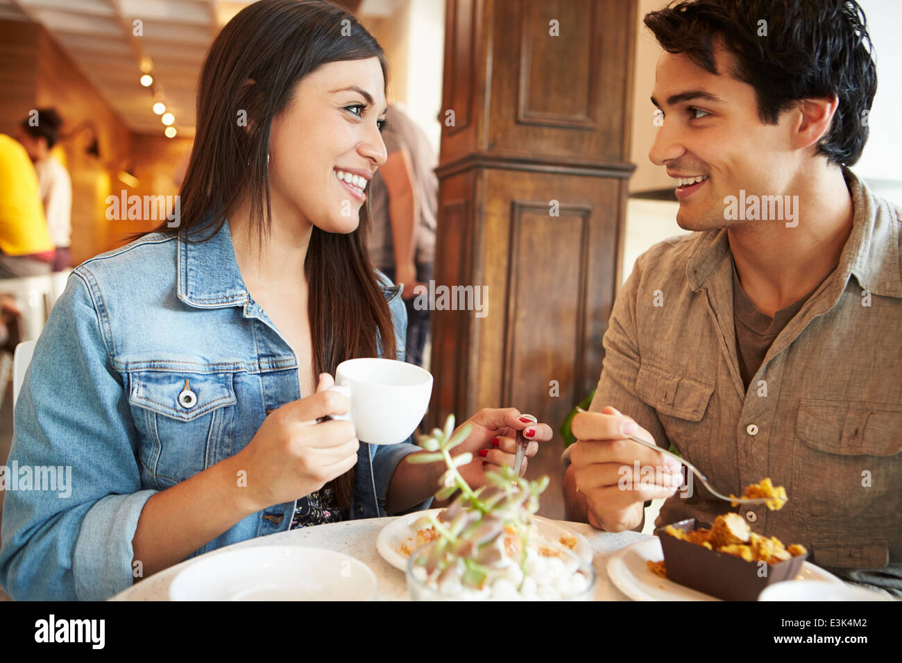 Giovane incontro in Busy Café Restaurant Foto Stock