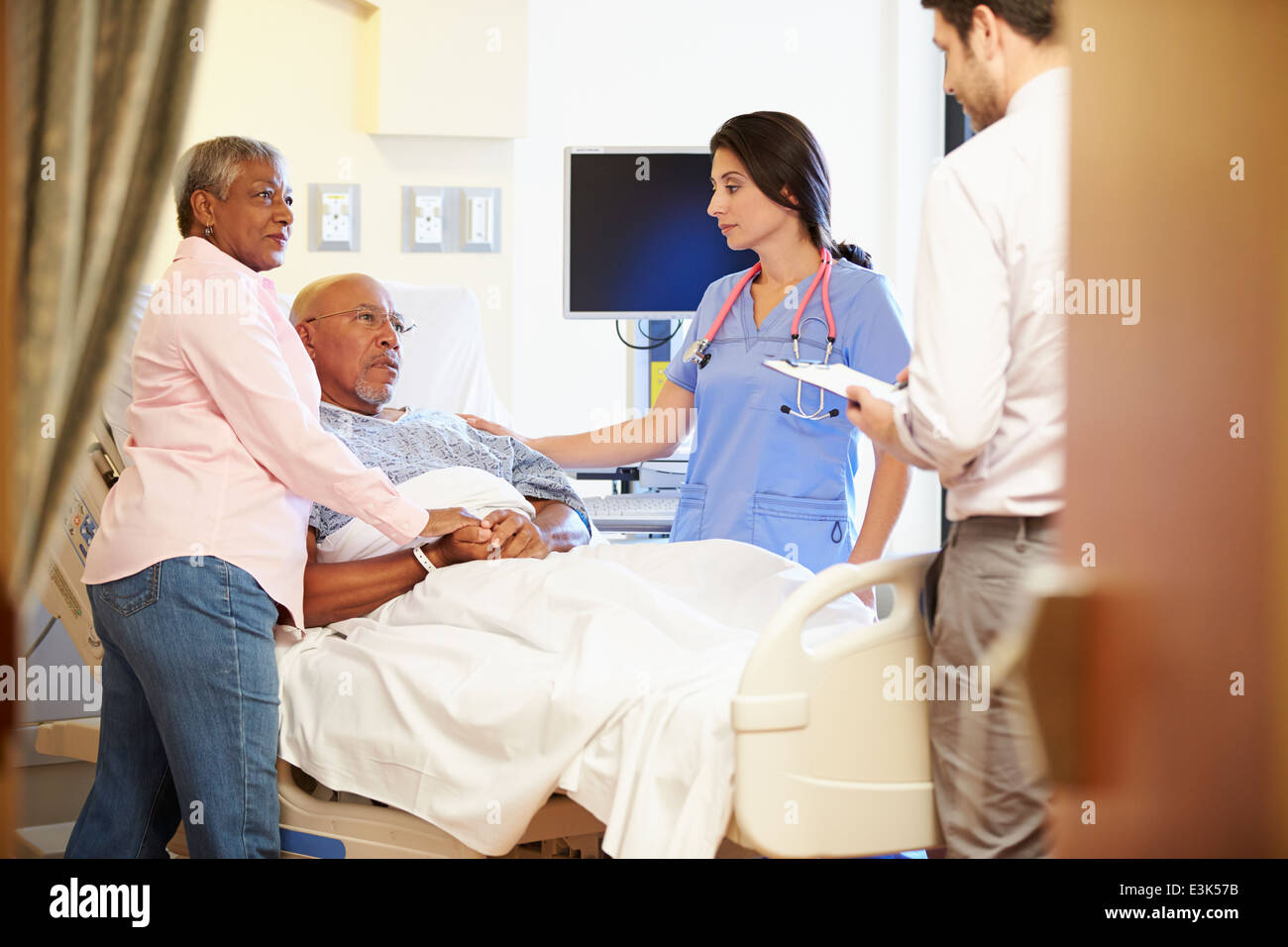 Il team medico di incontro con coppia Senior nella stanza di ospedale Foto Stock