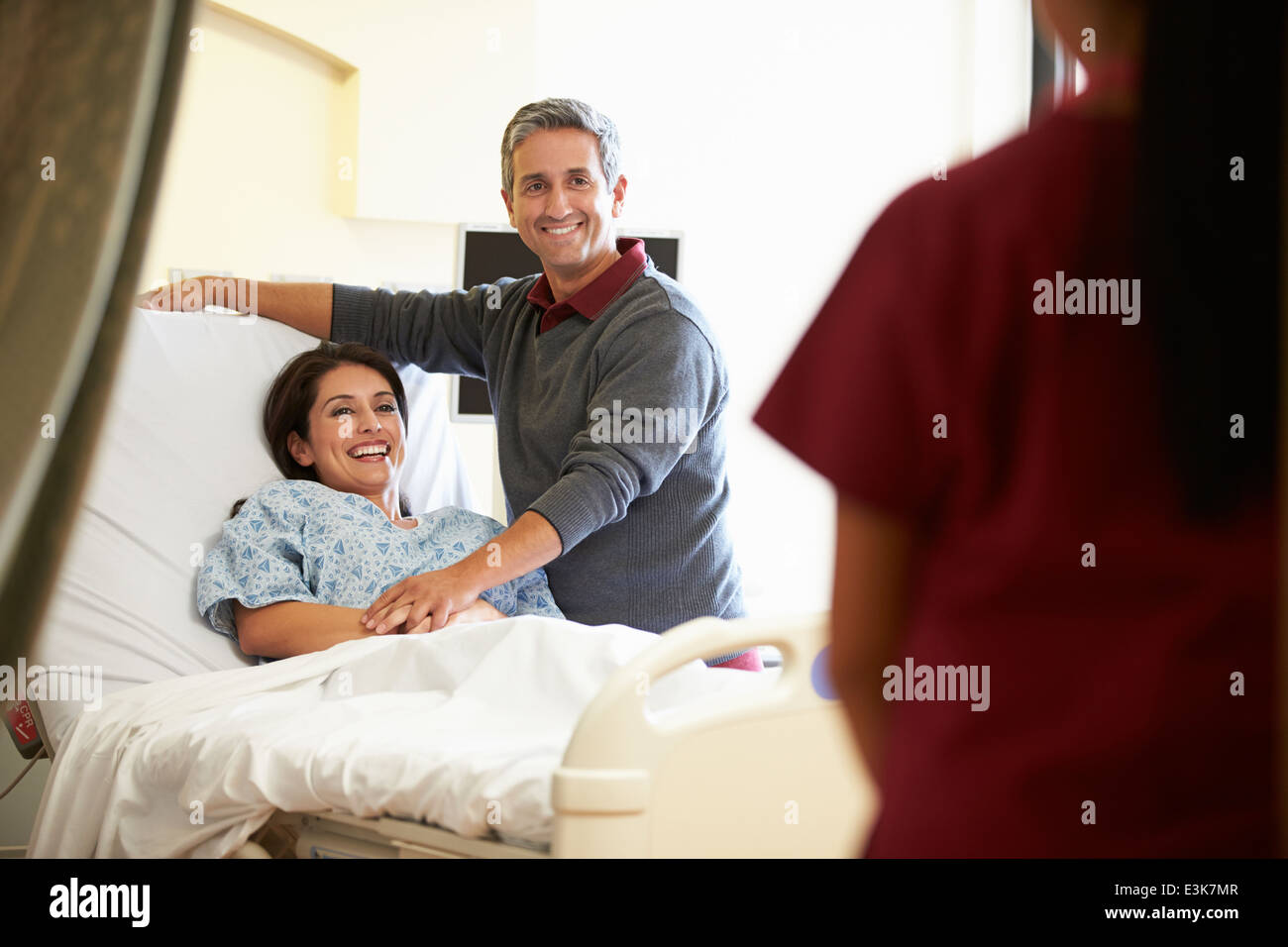 Marito moglie in visita in ospedale e parlando a un infermiere Foto Stock