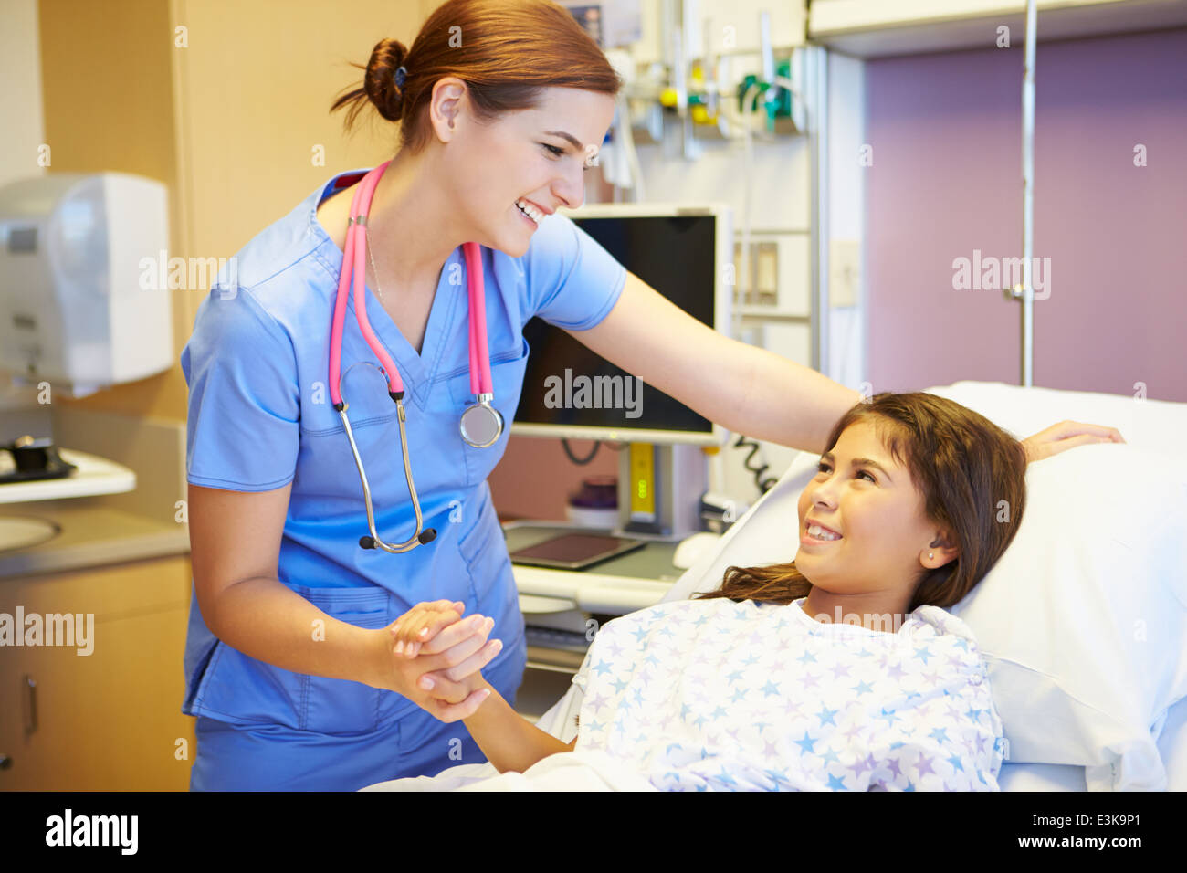 Ragazza giovane parlando a femmina infermiera nella stanza di ospedale Foto Stock