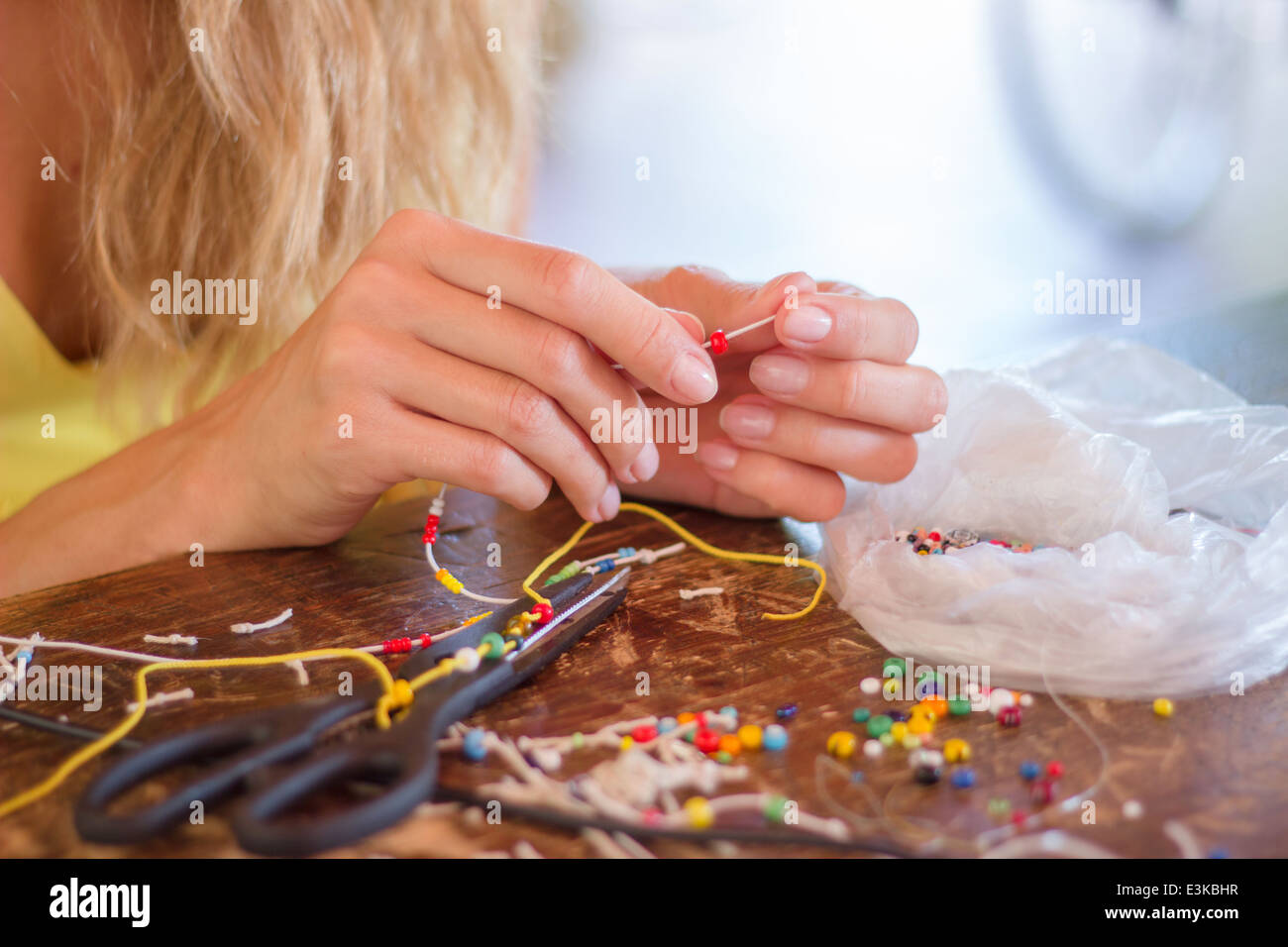 Donna mani di bordatura rendere le imbarcazioni creazione hobby bracciale perline colorate corda Foto Stock