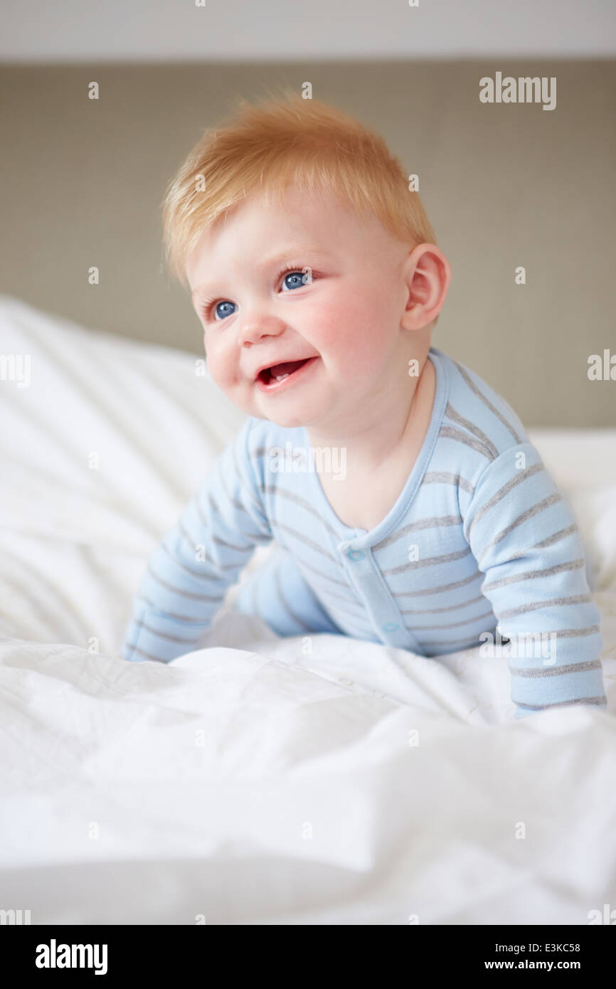 I giovani Baby Boy giocando a letto Foto Stock