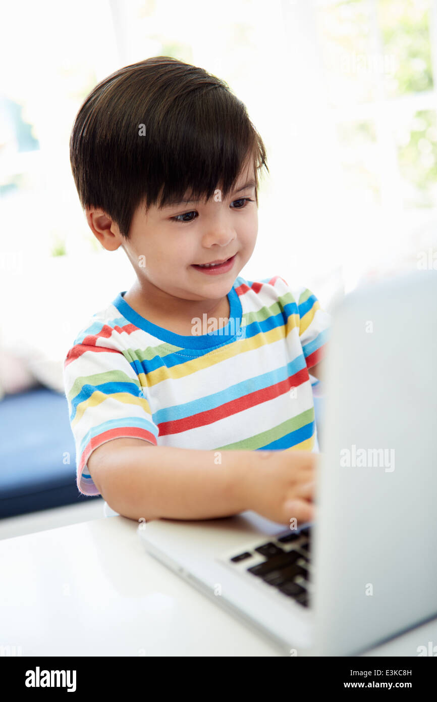 Bambino asiatico utilizzando portatile a casa Foto Stock