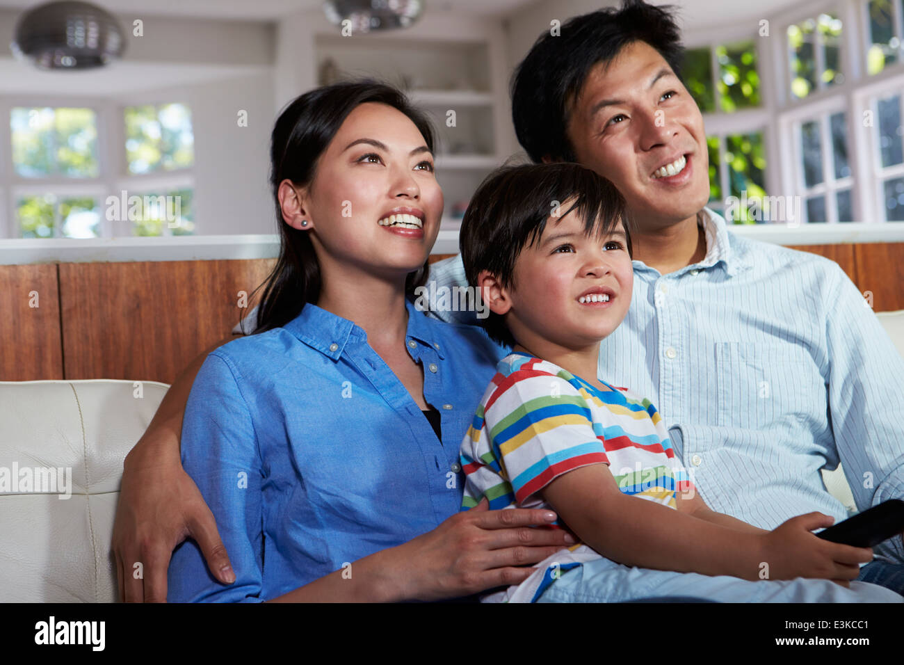 Famiglia asiatica seduto sul divano guardando la TV insieme Foto Stock
