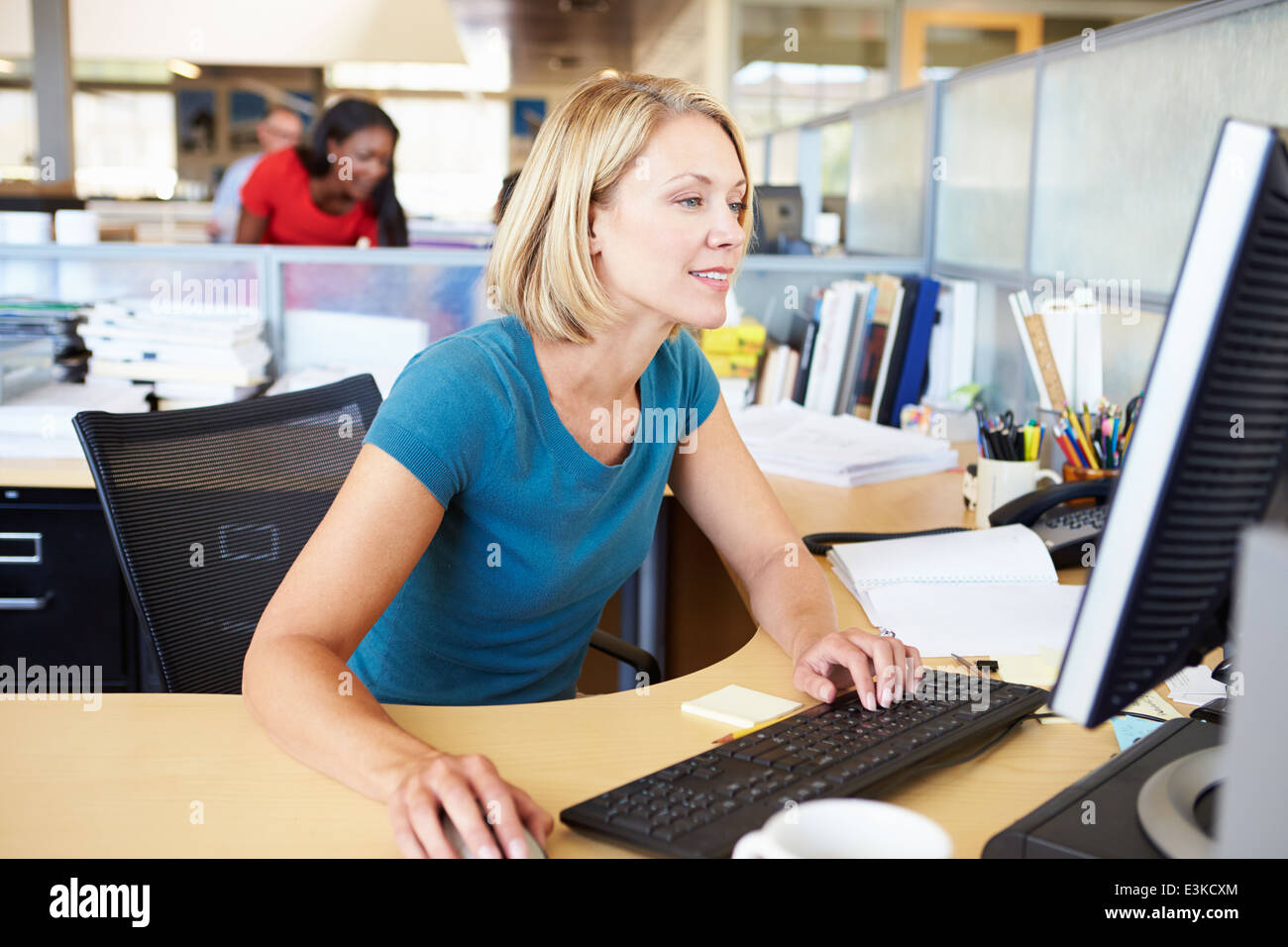 La donna lavora al computer in un ufficio moderno Foto Stock