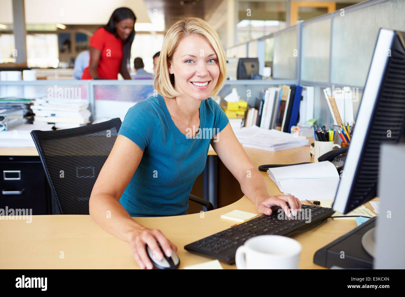 La donna lavora al computer in un ufficio moderno Foto Stock