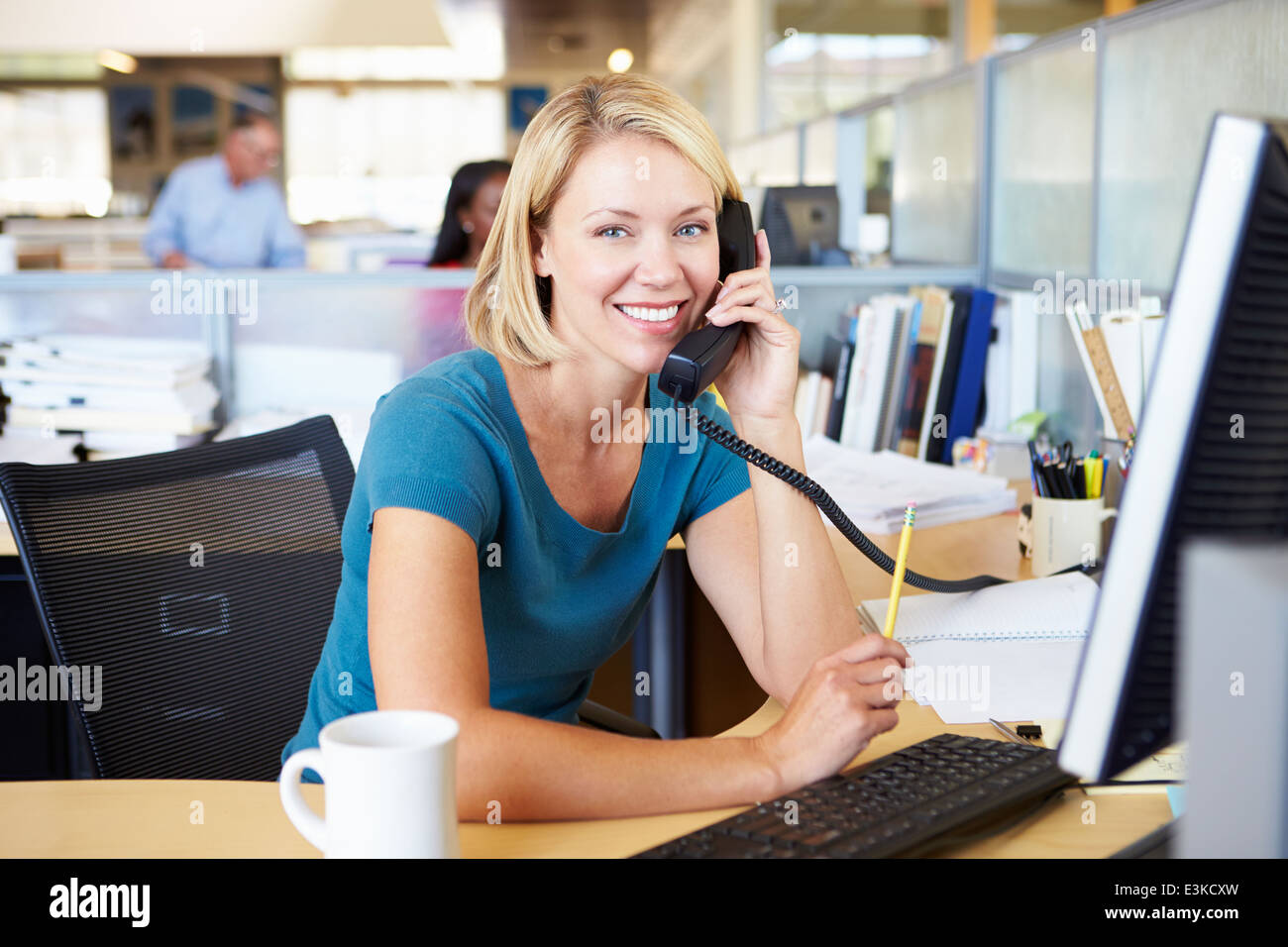 Donna al telefono occupato in ufficio moderno Foto Stock