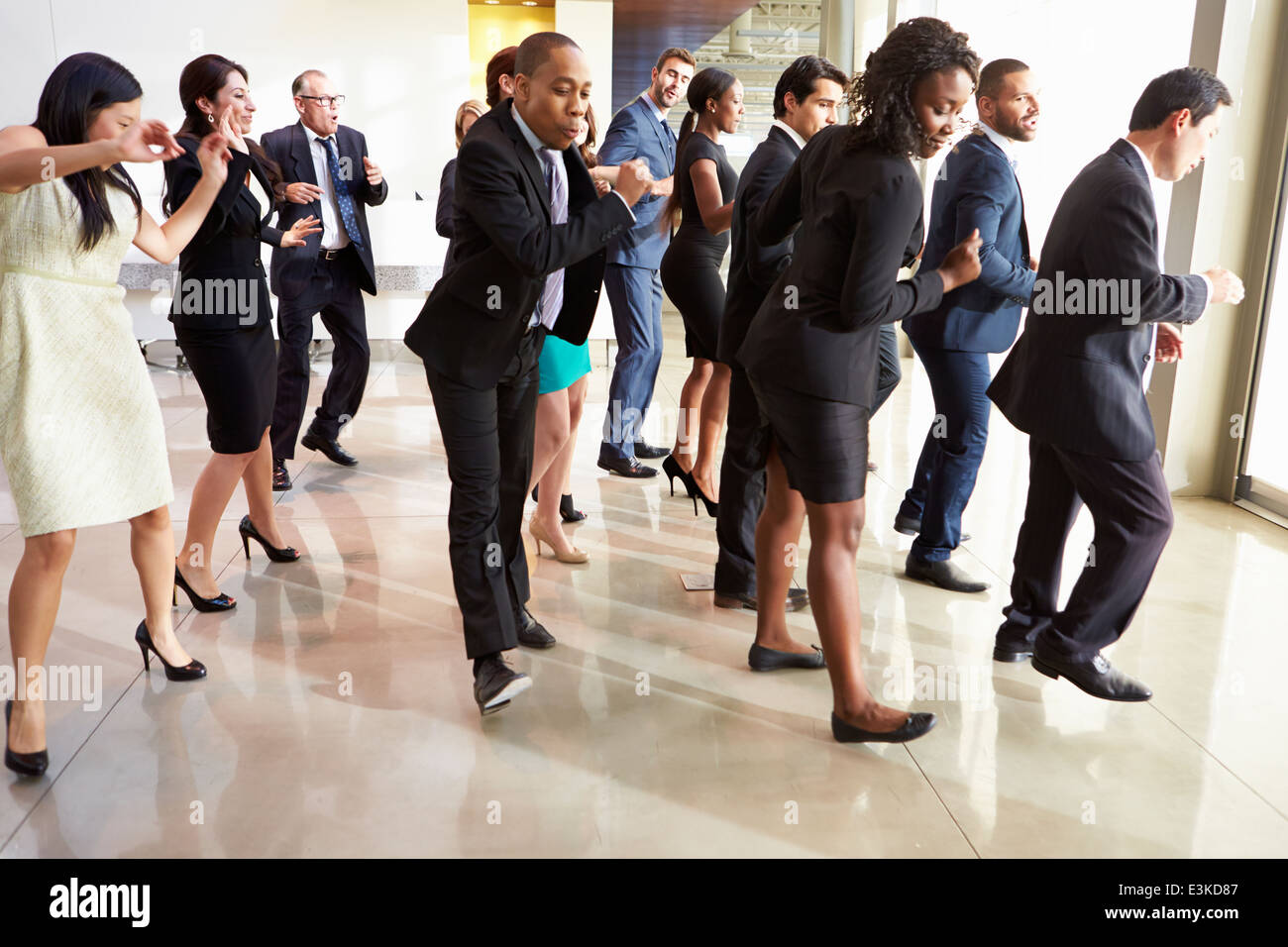 Imprenditori e imprenditrici Dancing in Office Lobby Foto Stock