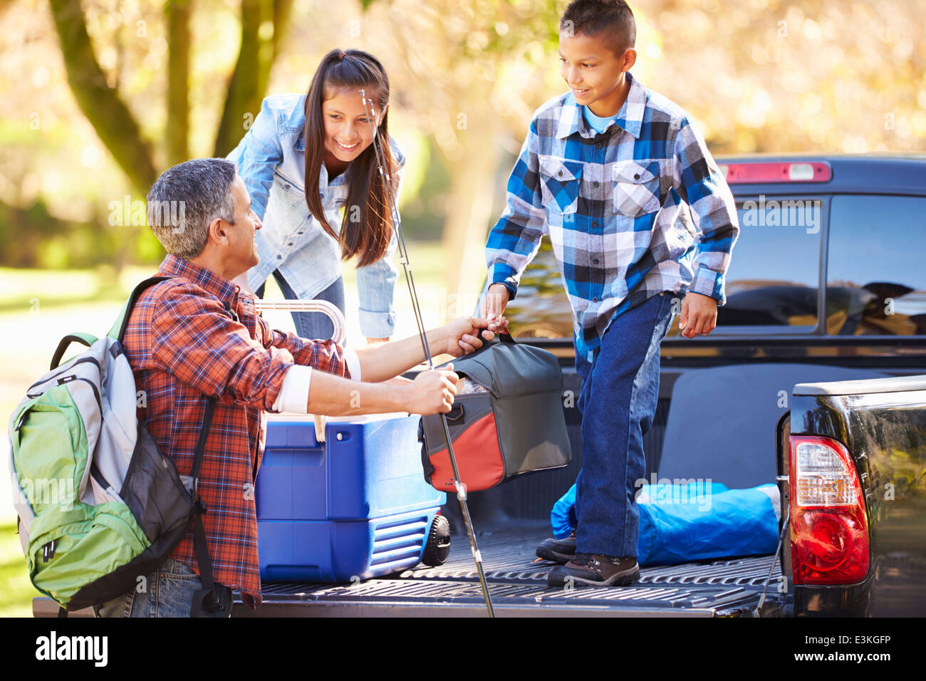 Padre e figli Disimballaggio Carrello in vacanza in campeggio Foto Stock