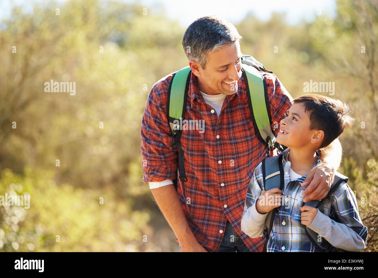 Padre e Figlio escursioni in campagna indossando zaini Foto Stock