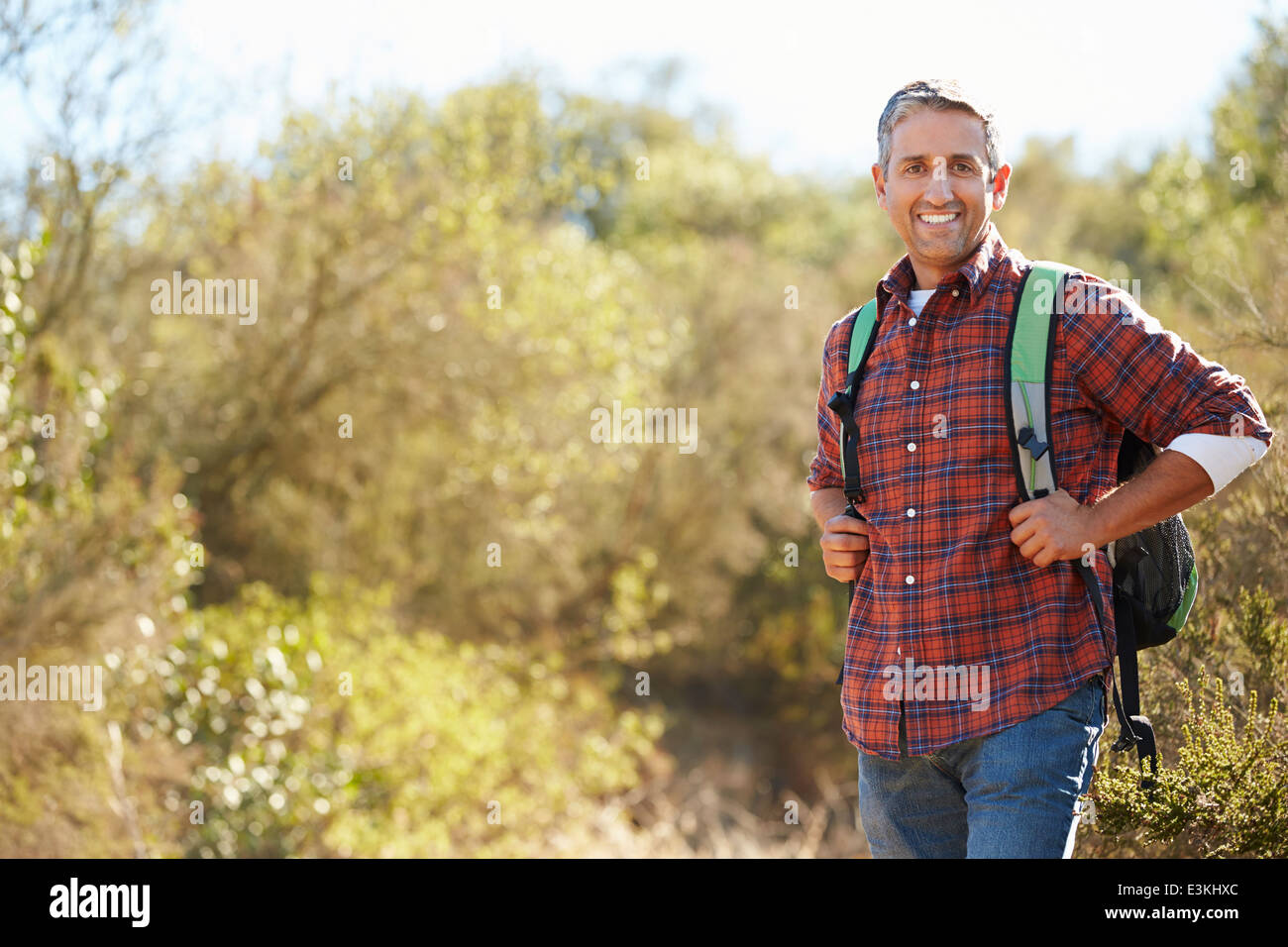Ritratto di uomo escursioni in campagna indossando uno zaino Foto Stock