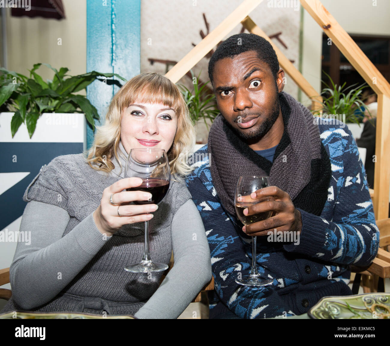 Ritratto di felice coppia uomo nero e la donna bianca con un bicchiere di vino a parte Foto Stock