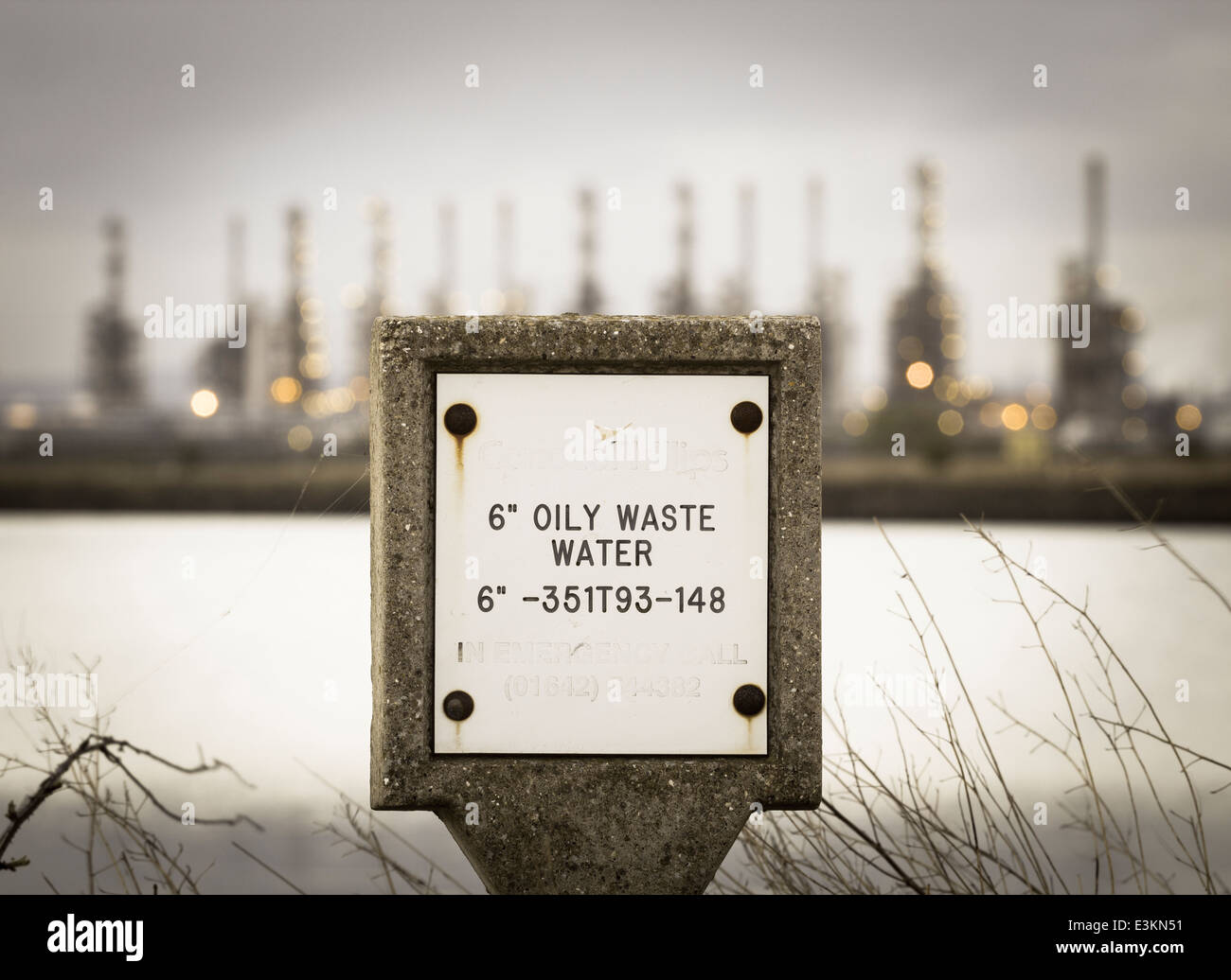 Acque reflue oleose marcatore pipeline con Conoco Phillips raffineria in background a Sigillo Sands, Teesside, Inghilterra. Regno Unito Foto Stock