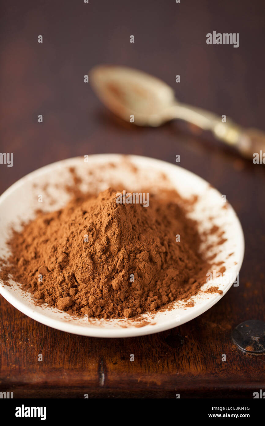 Cacao in polvere sulla piastra con cucchiaino Foto Stock