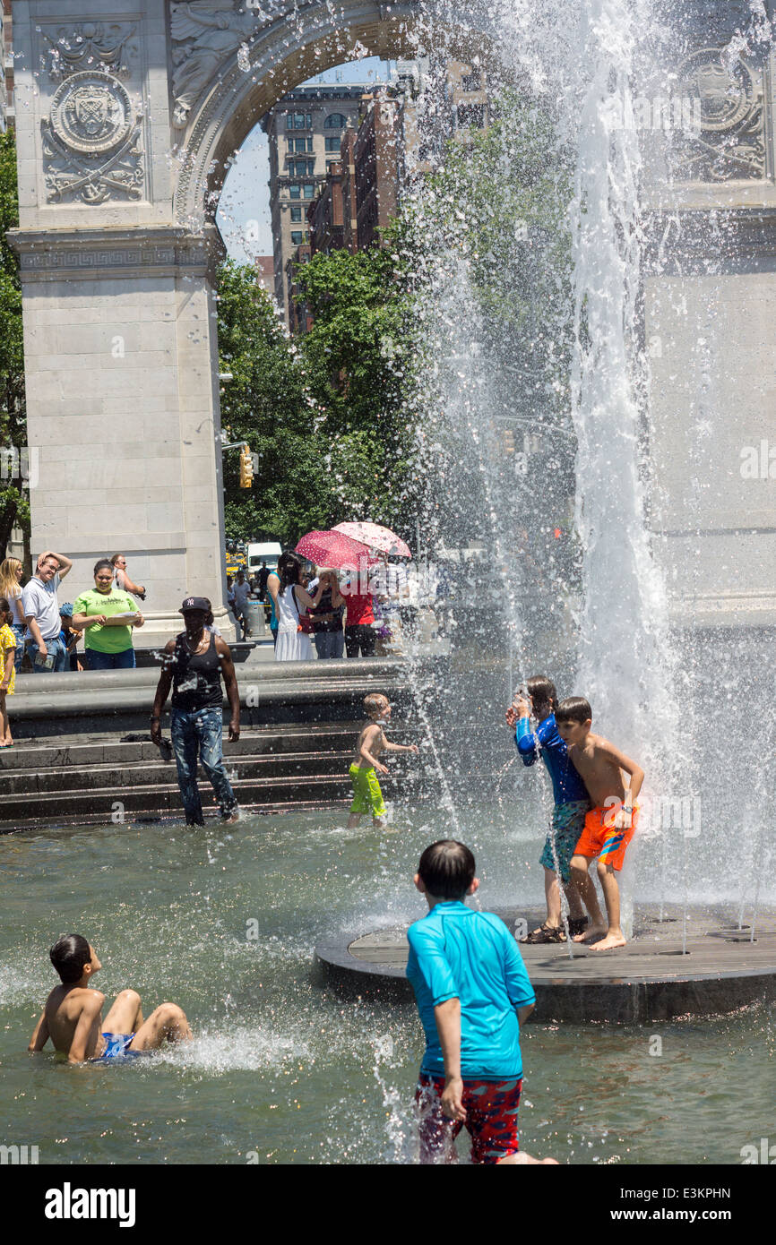 Soffocante Newyorkesi e visitatori gravitano verso i parchi con fontane, come Washington Square Park in Greenwich Village Foto Stock