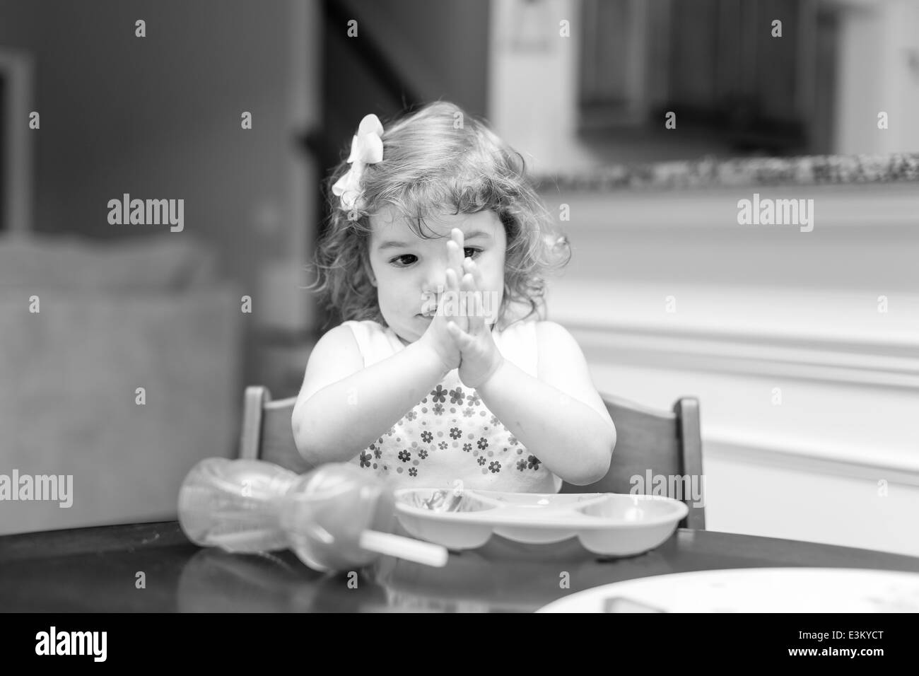 Bambina a ora di cena rendendo le espressioni del viso Foto Stock