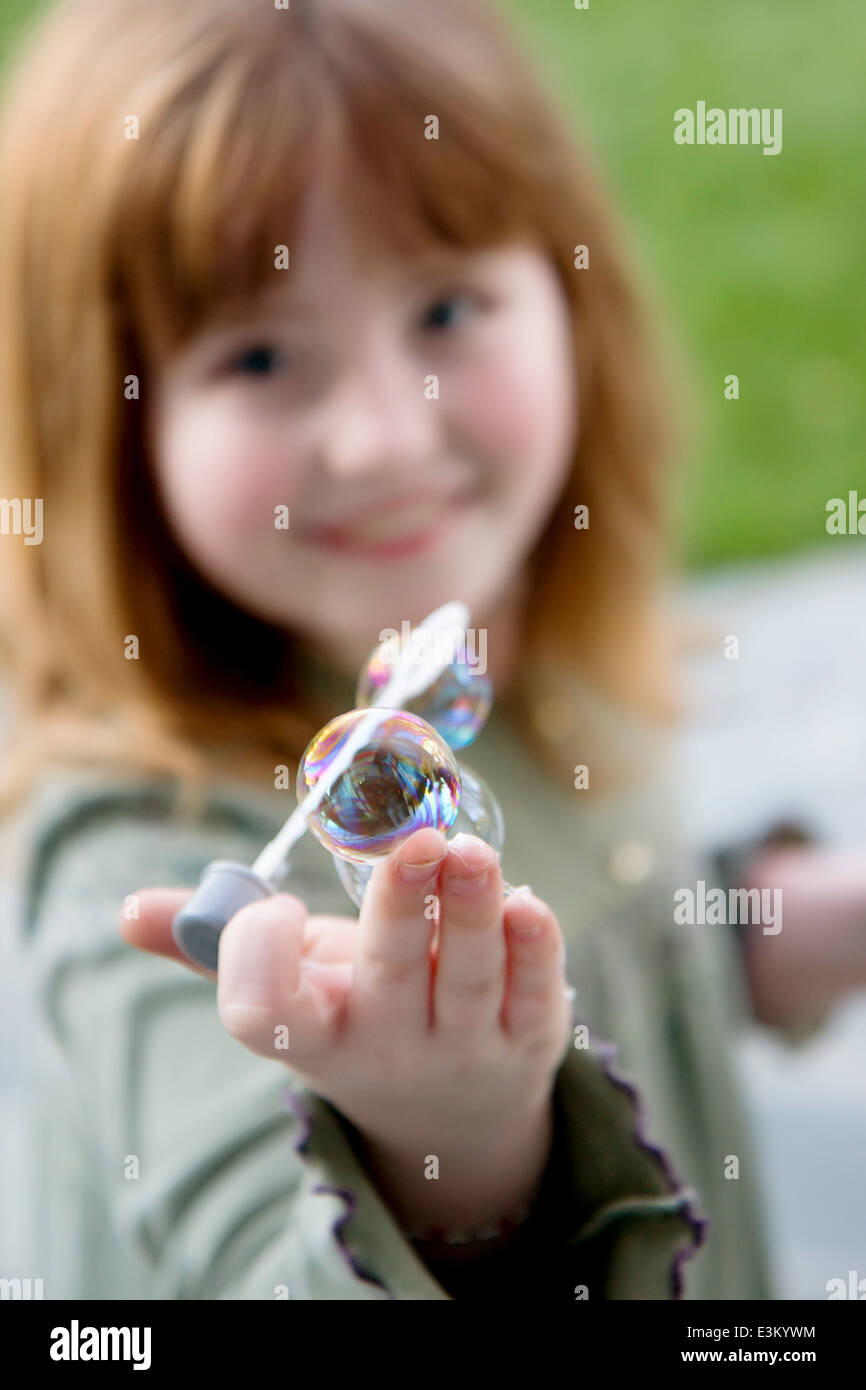 Immagine della ragazza (8-9) che mostra la bacchetta di bolle Foto Stock