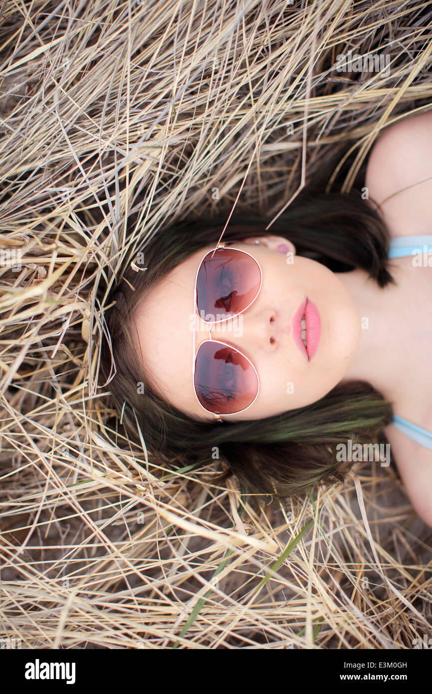 Ritratto di giovane donna sdraiata sul fieno, New Hampshire, STATI UNITI D'AMERICA Foto Stock