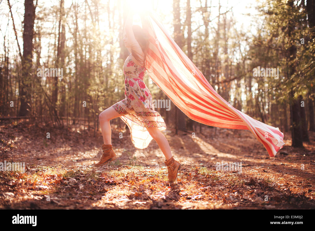 Immagine della giovane donna in esecuzione con coperta in foresta, Massachusetts, STATI UNITI D'AMERICA Foto Stock