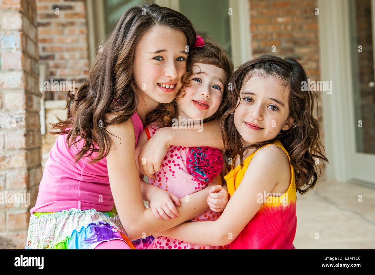 Ritratto di tre ragazze (8-9, 4-5, 10-12) abbracciando Foto Stock