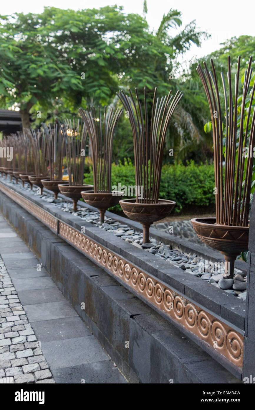 Muro di pietra e balaustra con gradini che conducono ad un ingresso sincronizzato in un lussureggiante giardino verde di Bali con uno scorcio di oceano verso il basso Foto Stock