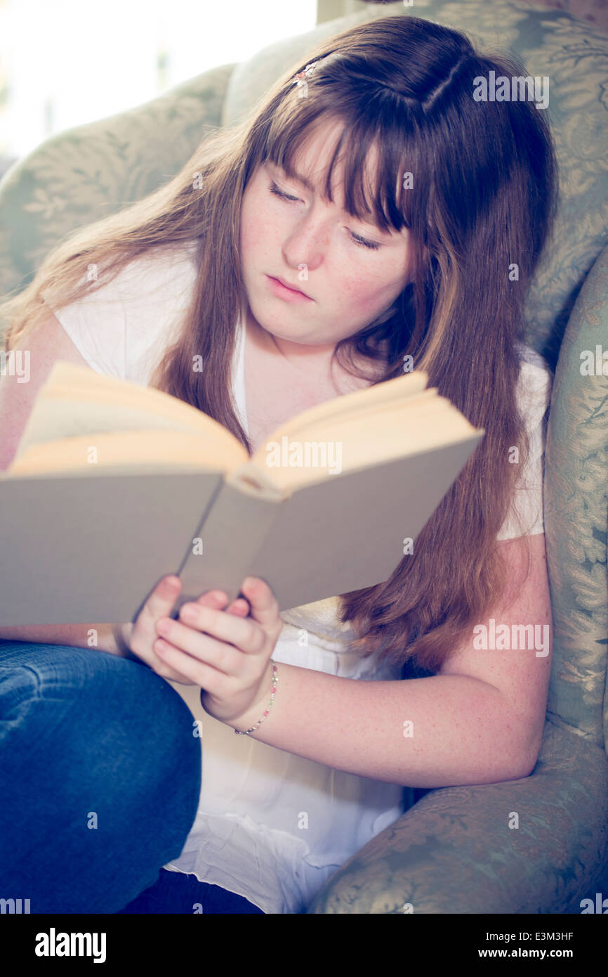 Immagine della ragazza adolescente (13-15) lettura del libro Foto Stock