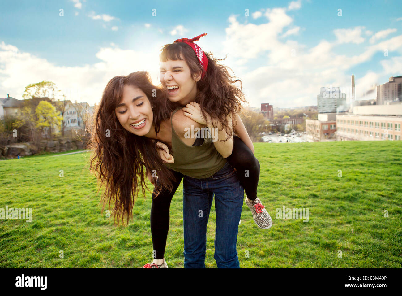 Giovane donna dando piggyback ride al suo amico Foto Stock